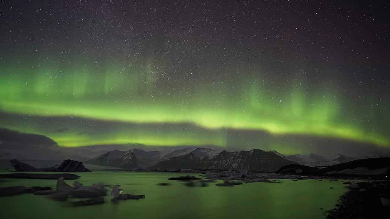 Take in the sights of the Northern Lights at a magical glacier lagoon in Jökulsárlón, Iceland.