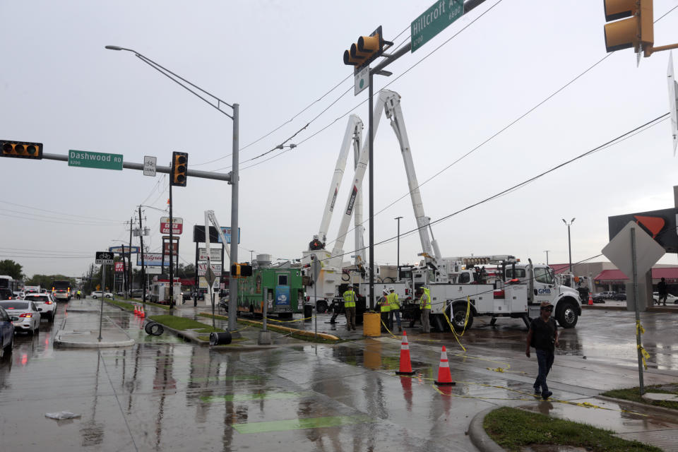 Utility crews work to restore electricity in Houston, Thursday, July 11, 2024. Officials say about 500,000 customers still won't have electricity into next week as wide outages from Hurricane Beryl persist. (AP Photo/Lekan Oyekanmi)