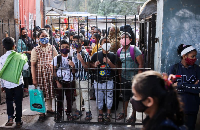 Students wait to enter a school after they reopened amidst the spread of the coronavirus disease (COVID-19) pandemic in Mumbai