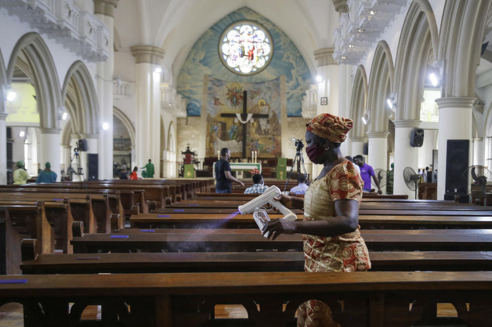 A church usher sprays disinfectant on pews to curb the spread of the coronavirus before a Sunday mass at the Holy Cross Cathedral in Lagos, Nigeria Sunday, Aug. 30, 2020. The COVID-19 pandemic is testing the patience of some religious leaders across Africa who worry they will lose followers, and funding, as restrictions on gatherings continue. (AP Photo/Sunday Alamba)
