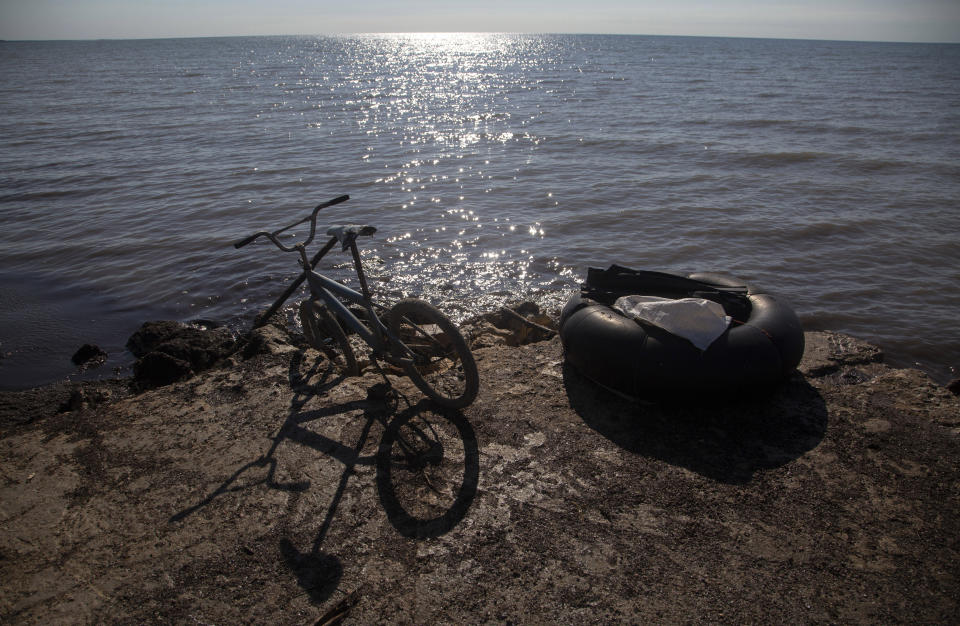 A bicycle and raft used by fishermen sits near the water in the Surgidero, in Batabano, Cuba, Tuesday, Oct. 25, 2022. Cuba is suffering from longer droughts, warmer waters, more intense storms, and higher sea levels because of climate change. (AP Photo/Ismael Francisco)