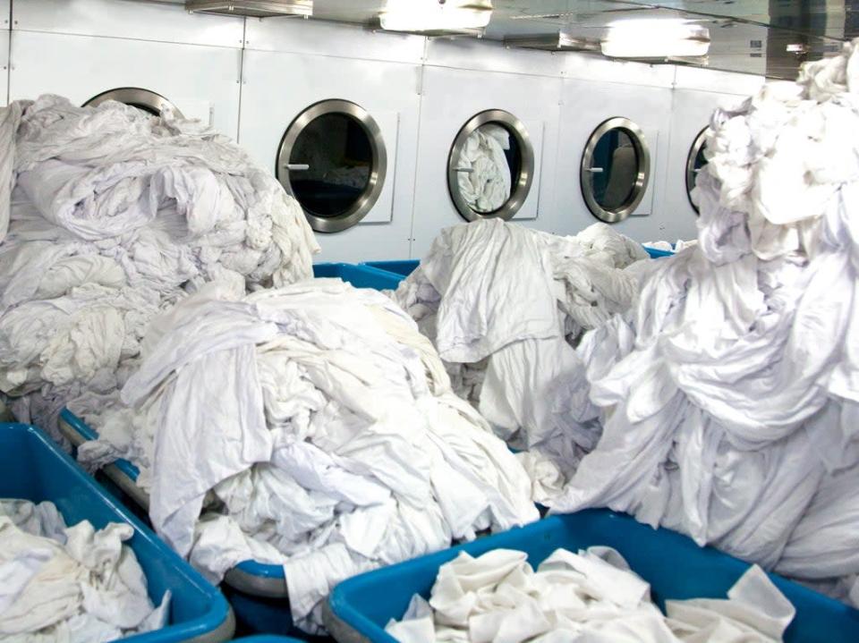 Mountains of sheets about to go into drying machines. Up to 40 times more microscopic fragments were generated by dryers than washing machines, scientists found in tests (Getty )