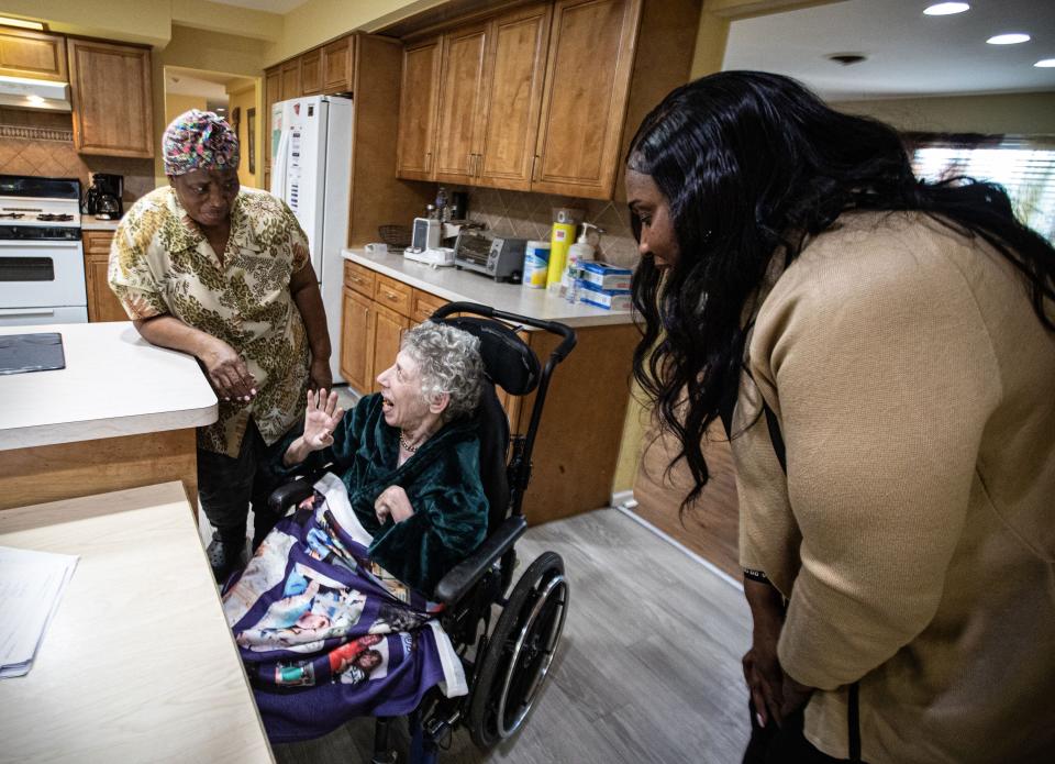 Marie Denise Pierre, left, a Direct Support Professional, or DSP, and Marcia Campbell, staff coordinator, spend time with Carol Fried, a resident at Jawonio’s Johansen Home in Monsey, Nov. 28, 2023. Carol is one of eight adults with severe disabilities living at the group home run by Jawonio, a non-profit that serves those with intellectual and developmental disabilities, and people with chronic medical needs. As wages for group home workers are set by the state, jobs remain empty and group homes around the state are being shuttered. Pierre and other workers say that they can’t make ends meet on the hourly wages set by the state.
