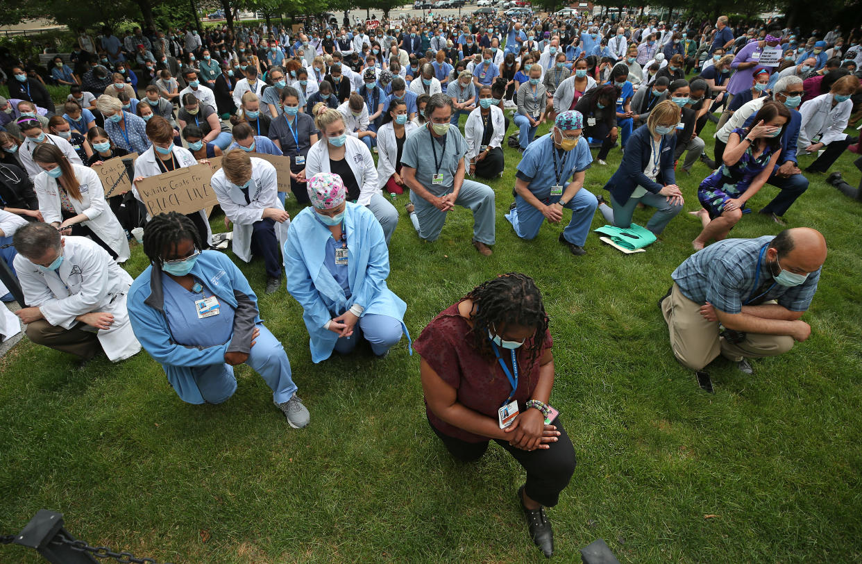 Doctors and nurses at Brigham and Women's Hospital in Boston kneel during a vigil in memory of George Floyd and reflection on racial injustice. (Photo by David L. Ryan/The Boston Globe via Getty Images)