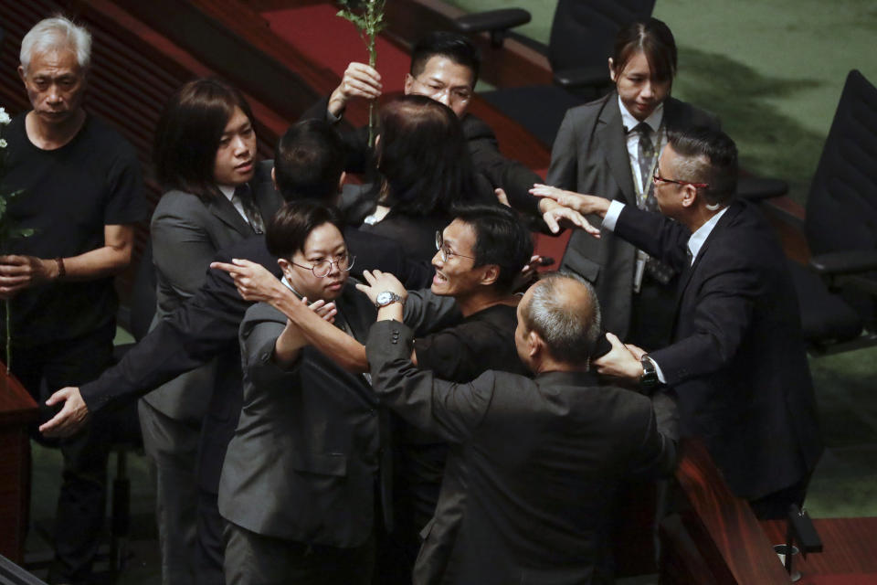 Pro-democracy lawmakers are restrained by security officials as Hong Kong Chief Executive Carrie Lam attends a question and answer session at the chamber of the Legislative Council in Hong Kong, Thursday, Oct. 17, 2019. (AP Photo/Mark Schiefelbein)