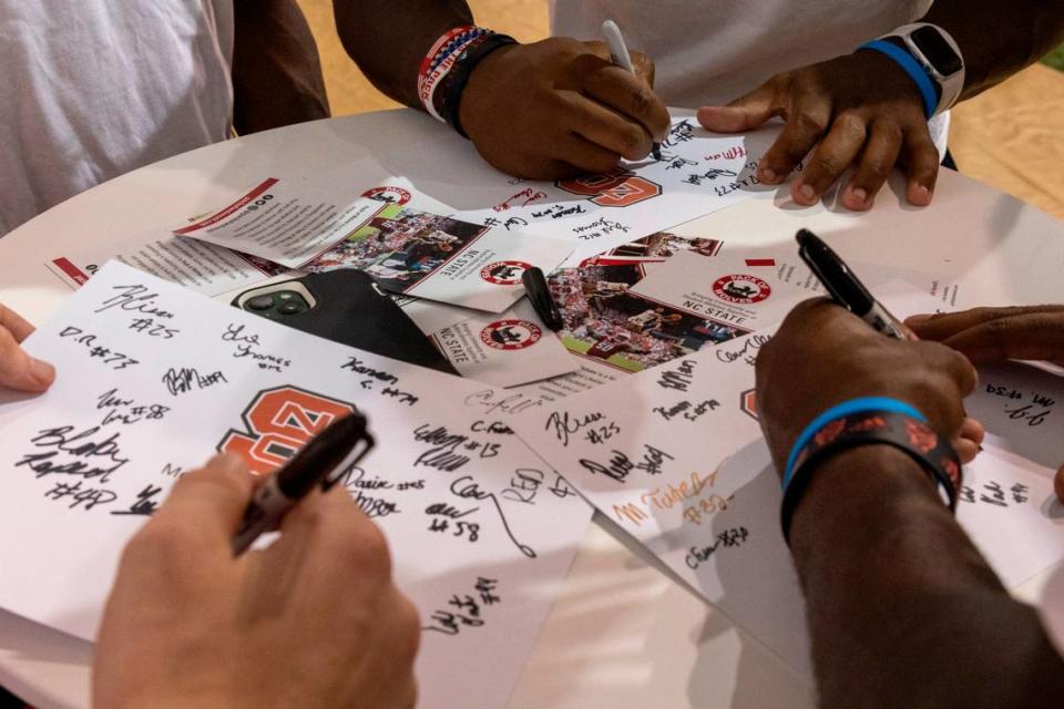N.C. State football payers sign autographs during a ‘Meet the Pack’ event with players and fans at the Close-King Indoor Practice Facility Saturday, Aug. 16, 2023.