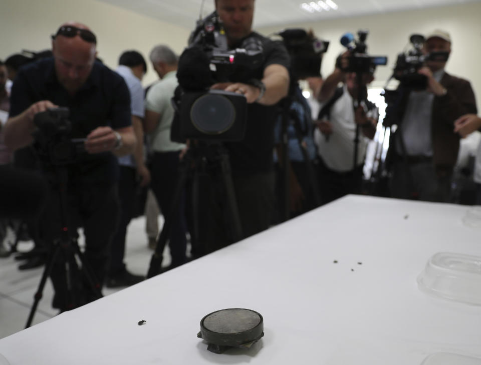 Journalists take pictures of a magnet the U.S. Navy says came from a limpet mine that didn't explode on a Japanese-owned oil tanker at a 5th Fleet base, during a trip organized by the Navy for journalists, near Fujairah, United Arab Emirates, Wednesday, June 19, 2019. Cmdr. Sean Kido of the U.S. Navy's 5th Fleet said Wednesday that the limpet mine used on a Japanese-owned oil tanker last week "bears a striking resemblance" to similar Iranian mines. (AP Photo/Kamran Jebreili)