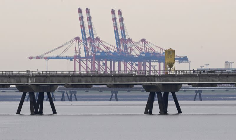 A pier for a planned floating LNG gas terminal is pictured in front of a container terminal in the harbour in Wilhelmshaven