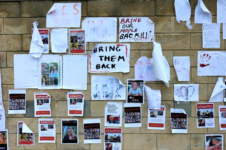 Images of Israeli hostages snatched by the Palestinian militant group Hamas last week in a surprise attack into Israel, are plastered on a wall during a rally outside the Ministry of Defense in Tel Aviv on October 16, 2023. The Israeli military on October 16, raised the figure to 199 people confirmed to have been abduced by Hamas to the Gaza Strip in the militants' cross-border attacks on October 7 which sparked a devastating war.. (Photo by AHMAD GHARABLI / AFP)