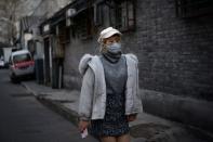 Woman wearing a face mask walks at a hutong, as the country is hit by an outbreak of the novel coronavirus, in Beijing