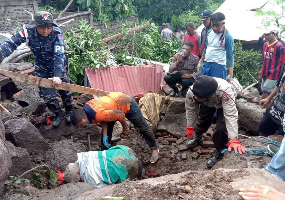 Rescuers search for victims at a village hit by a landslide in Ile Ape Timur on Lembata Island, East Nusa Tenggara province, Indonesia, Monday, April 5, 2021. Multiple disasters caused by torrential rains in eastern Indonesia and neighboring East Timor have left a number of people dead or missing as rescuers were hampered by damaged bridges and roads and a lack of heavy equipment Monday. (AP Photo/Ricko Wawo)