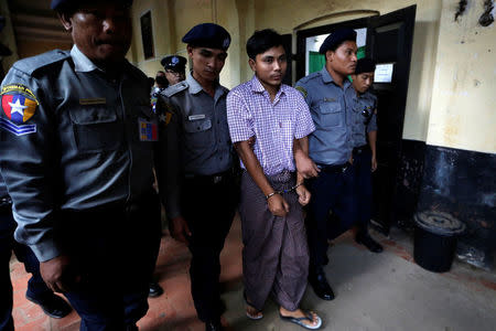 Detained Reuters journalist Kyaw Soe Oo walks escorted by police during a break at a court hearing in Yangon, Myanmar June 4, 2018. REUTERS/Ann Wang