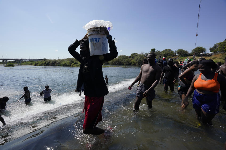 Haitian migrants use a dam to cross to and from the United States from Mexico, Friday, Sept. 17, 2021, in Del Rio, Texas. Thousands of Haitian migrants have assembled under and around a bridge in Del Rio presenting the Biden administration with a fresh and immediate challenge as it tries to manage large numbers of asylum-seekers who have been reaching U.S. soil. (AP Photo/Eric Gay)