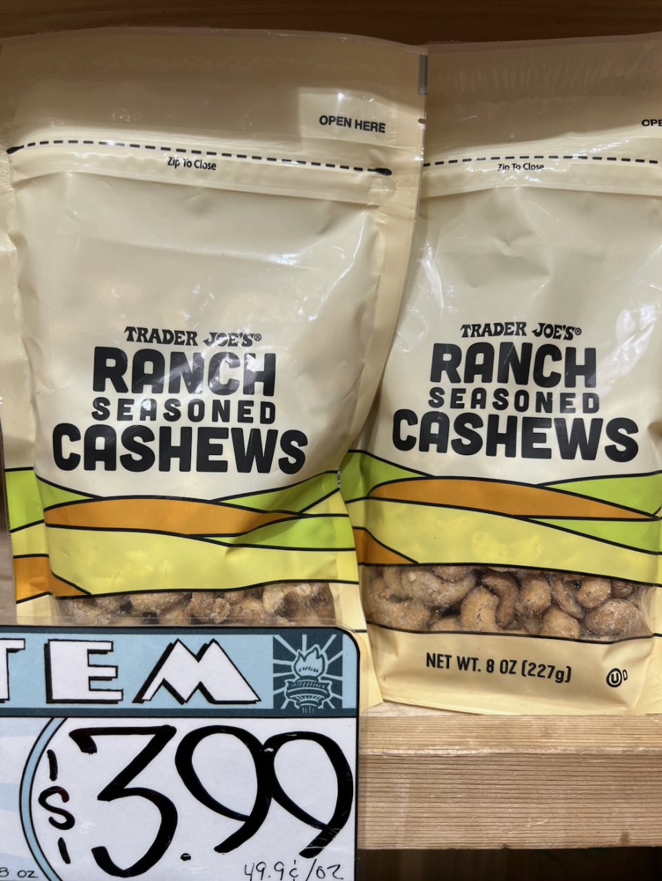 Two bags of Trader Joe's Ranch Seasoned Cashews on display. One bag is opened, and a price tag at the bottom shows the price as $3.99