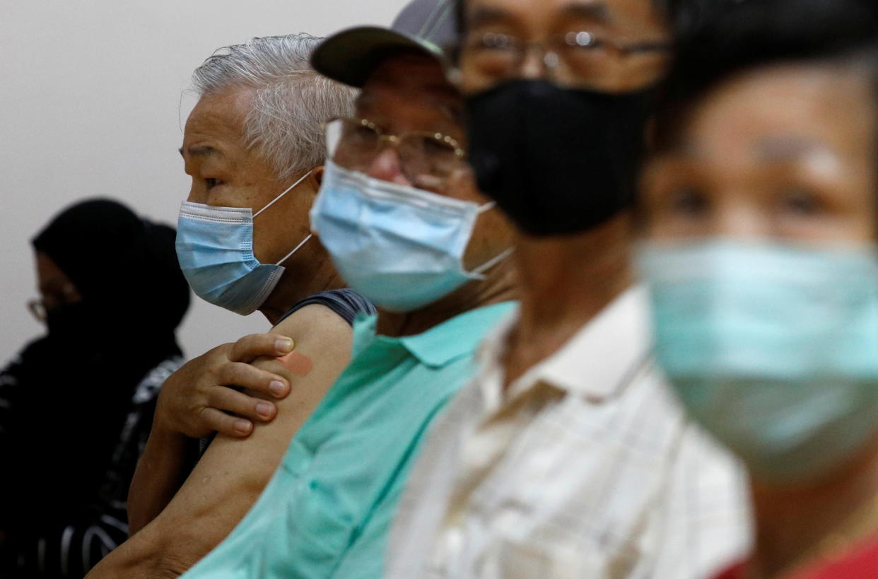 People wait at an observation area after their vaccination at a coronavirus disease vaccination centre in March, 2021