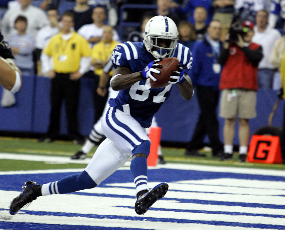 FILE - In this Oct. 17, 2005, file photo, Indianapolis Colts receiver Reggie Wayne catches a touchdown pass from quarterback Peyton Manning in the second quarter against the St. Louis Rams in Indianapolis. Wayne was selected as a finalist for the Pro Football Hall of Fame's class of 2021 on Tuesday, Jan. 5, 2021. (AP Photo/Michael Conroy, File)