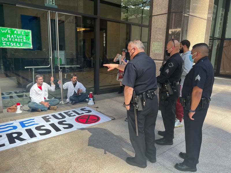 Police point at protestors chained to Chase Bank. 
