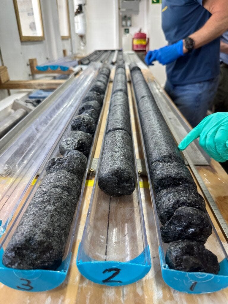 Aboard the JOIDES Resolution research vessel, team members process samples of mantle rock recovered from a more than 4,100-foot-deep hole drilled into the seabed of the North Atlantic.