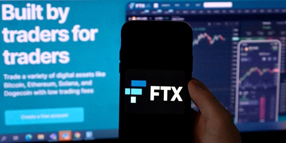 Illustration photo shows a smart phone screen displaying the logo of FTX, the crypto exchange platform, with a screen showing the FTX website