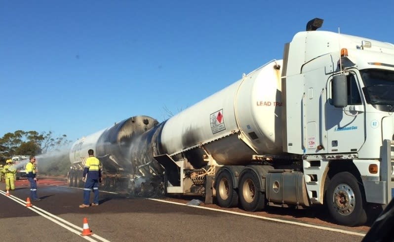 Firefighters hose down the damaged tanker. Picture: Steven Deckert.