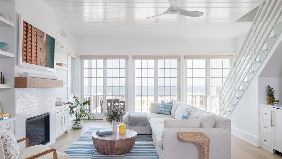 a white living room with a fireplace and white sofa