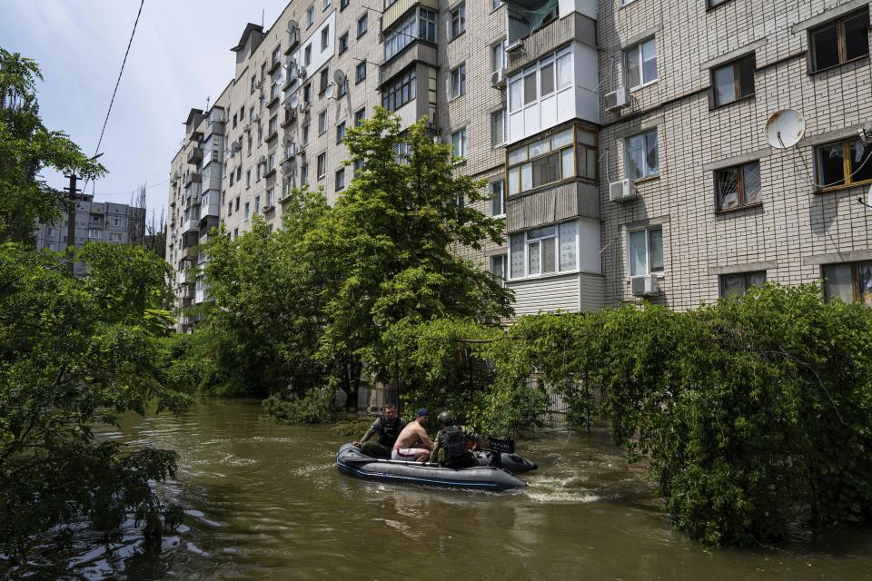 Ukrainian servicemen evacuate a man by a boat from a flooded neighborhood in Kherson, Ukraine, Thursday, June 8, 2023. Floodwaters from a collapsed dam kept rising in southern Ukraine on Wednesday, forcing hundreds of people to flee their homes in a major emergency operation that brought a dramatic new dimension to the war with Russia, now in its 16th month. (AP Photo/Evgeniy Maloletka)