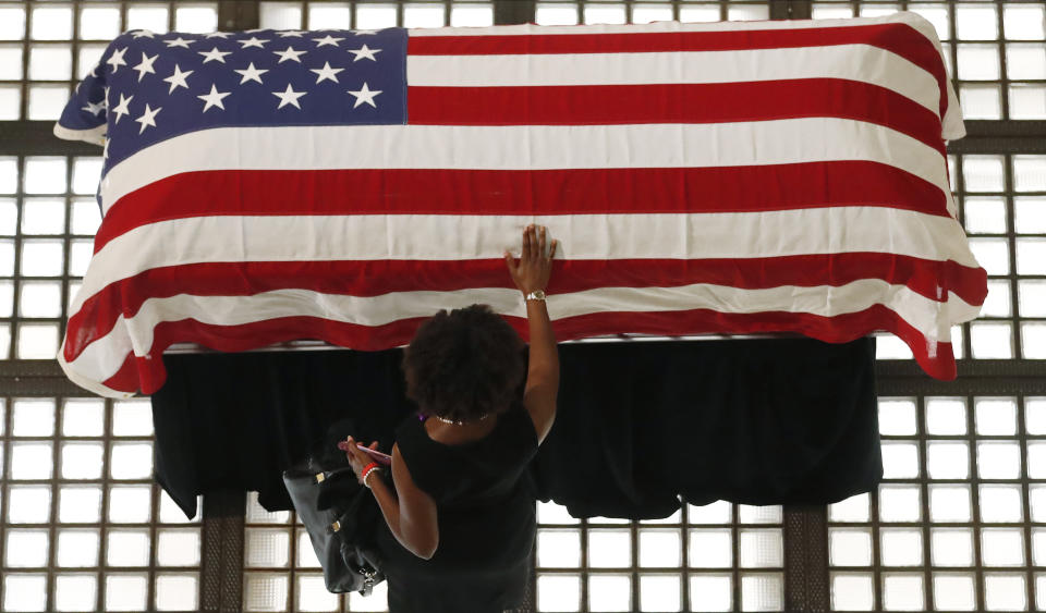 A mourner pauses by the casket of Rep. John Lewis lying in repose at the state capital, Wednesday, July 29, 2020, in Atlanta. Lewis, who carried the struggle against racial discrimination from Southern battlegrounds of the 1960s to the halls of Congress, died Friday, July 17, 2020. (AP Photo/John Bazemore)