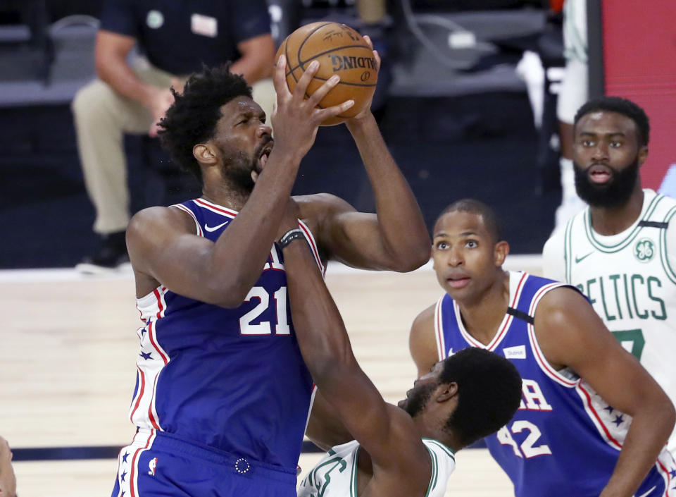 Philadelphia 76ers center Joel Embiid (21) is fouled by Boston Celtics forward Semi Ojeleye, bottom, during the second quarter of Game 4 of an NBA basketball first-round playoff series, Sunday, Aug. 23, 2020, in Lake Buena Vista, Fla. (Kim Klement/Pool Photo via AP)