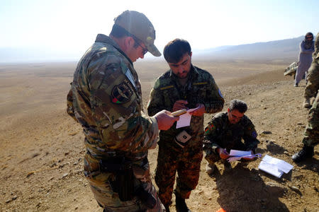 An American military adviser consults with an Afghan Tactical Air Controller during an exercise at a range outside Kabul, Afghanistan, October 18, 2016. REUTERS/Josh Smith