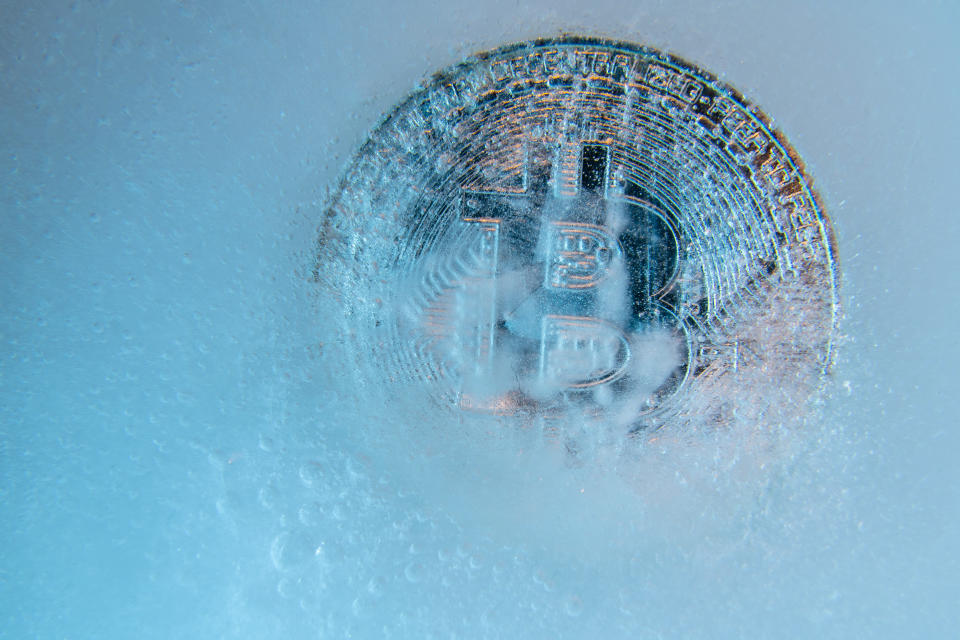 Prague, Czech Republic - June, 2019: Silver Bitcoin, bit coin online digital currency frozen in the blue ice. Concept of block chain, crypto market crash. Frozen crypto money, depreciation