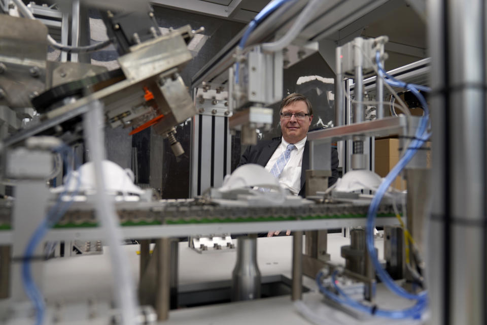 Jim Schmersahl, owner of Halcyon Shades, poses with a machine used to make N-95 masks Friday, March 18, 2022, in University City, Mo. Halcyon is small company that normally makes window shades, but when the pandemic hit, its sales plummeted. Halcyon applied for the state grants to make PPE as a way to try to keep its employees at work and keep the company afloat. (AP Photo/Jeff Roberson)