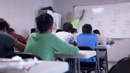 A teacher instructs mathematics at the HHS unaccompanied minors migrant detention facility at Carrizo Springs