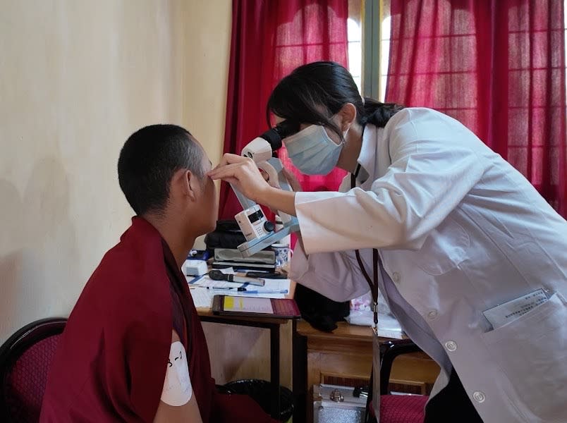 視力有問題的喇嘛，接受義診團隊的長庚眼科醫師檢查。（圖:林口長庚醫院提供）