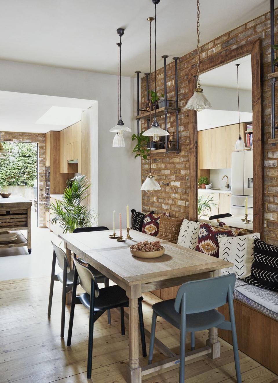 modern kitchen dining area with exposed brick walls and built in banquette seating