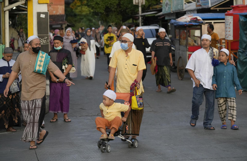 Muslims arrive for a morning prayer marking the Eid al-Adha holiday on a street in Jakarta, Indonesia, Sunday, July 10, 2022. Muslims around the world will celebrate Eid al-Adha, or Festival of Sacrifice, slaughtering sheep, goats, cows and camels to commemorate Prophet Abraham's readiness to sacrifice his son Ismail on God's command. (AP Photo/Tatan Syuflana)