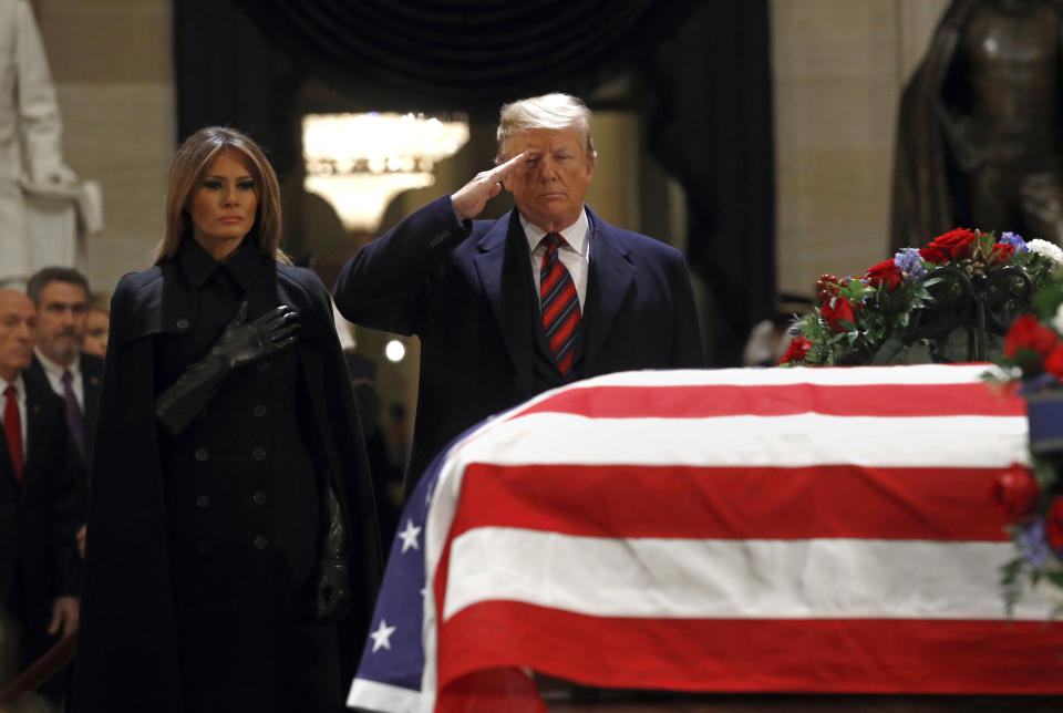 President Trump salutes the flag-draped casket of former President George H. W. Bush in the Capitol Rotunda in Washington on Dec. 3, 2018, as first lady Melania Trump looks on. (Photo: Patrick Semansky/AP)