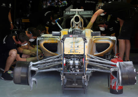 Formula One - F1 - Malaysia Grand Prix - Sepang, Malaysia- 30/9/16 Crew members work on the damaged car of Renault's Kevin Magnussen of Denmark after it caught fire in the first practice. REUTERS/Edgar Su