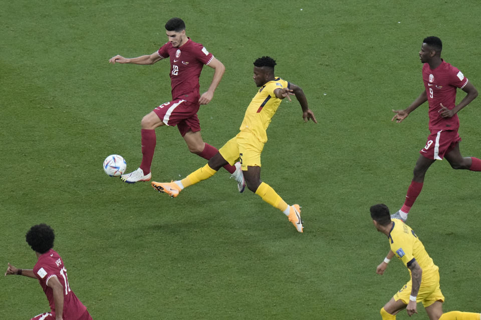 Qatar's Karim Boudiaf, left top, and Ecuador's Jose Cifuentes challenge for the ball during the World Cup group A soccer match between Qatar and Ecuador at the Al Bayt Stadium in Al Khor, Qatar, Sunday, Nov. 20, 2022. (AP Photo/Hassan Ammar)