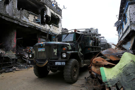 Government military trucks pass by damaged building and houses in Sultan Omar Dianalan boulevard at Mapandi district in Marawi city, southern Philippines September 13, 2017. REUTERS/Romeo Ranoco