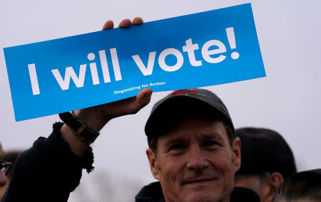 A man holds a sign as teens kick off a voter registration rally, a day ahead of the 19th anniversary of the massacre at Columbine High School, in Littleton, Colorado, U.S., April 19, 2018. REUTERS/Rick Wilking