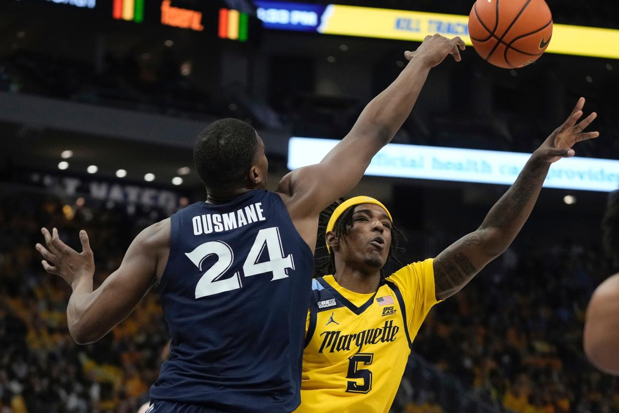 Marquette's Tre Norman shoots past Xavier's Abou Ousmane during the first half of an NCAA college basketball game Sunday, Feb. 25, 2024, in Milwaukee.