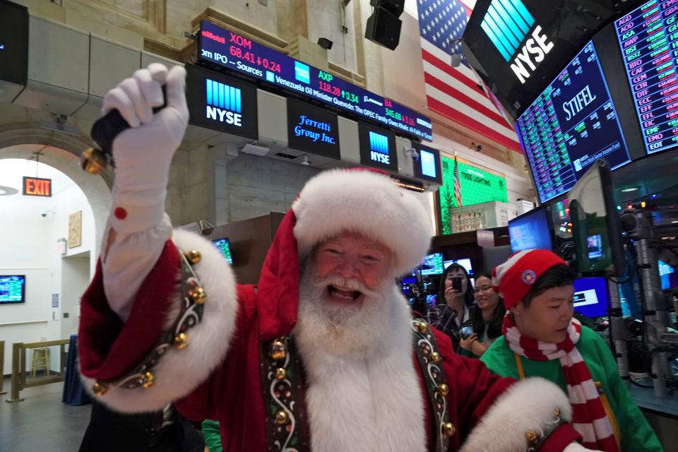 Um homem vestido de Papai Noel aponta para o chão no sino de fechamento do Índice Dow Industrial na Bolsa de Valores de Nova York em 5 de dezembro de 2019 em Nova York.  As ações de Wall Street fecharam ligeiramente em alta após uma sessão agitada que evitou as grandes oscilações vistas no início da semana nas notícias voltadas para o comércio.  Negociadores dos EUA e da China estão trabalhando para finalizar um acordo comercial provisório, anunciado em outubro, que bloquearia as novas tarifas que devem entrar em vigor neste mês.  As autoridades enviaram sinais confusos sobre as negociações, enviando ações flutuantes.  (Foto de Brian R. Smith / AFP) (Foto de Brian R. Smith / AFP via Getty Images)