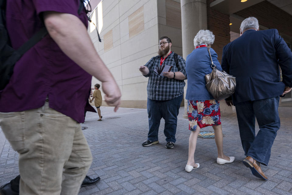 Dave Mitchell, of Houston, Texas, distributes brochures to promote the call to ratify an amendment that would bar churches with women pastors from the Southern Baptist Convention during the denomination’s annual meeting Tuesday, June 11, 2024, in Indianapolis. (AP Photo/Doug McSchooler)