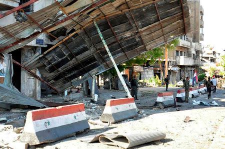 Syrian army soldiers stand at a site of an explosion in Bab Tadmor in Homs, Syria in this handout picture provided by SANA on September 5, 2016. SANA/Handout via REUTERS