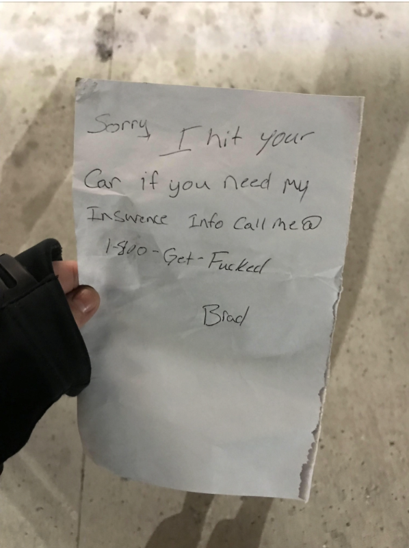 A person's hand holds a note that reads, "Sorry, I hit your car if you need my insurance info call me @ 1-800-Get-Fucked - Brad."
