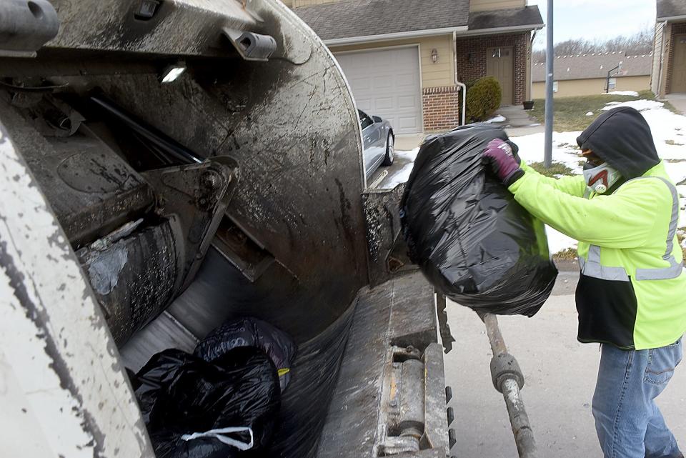 City of Columbia refuse collector Ian Brooks tosses trash bags into a trash truck on Feb. 9 in south Columbia.