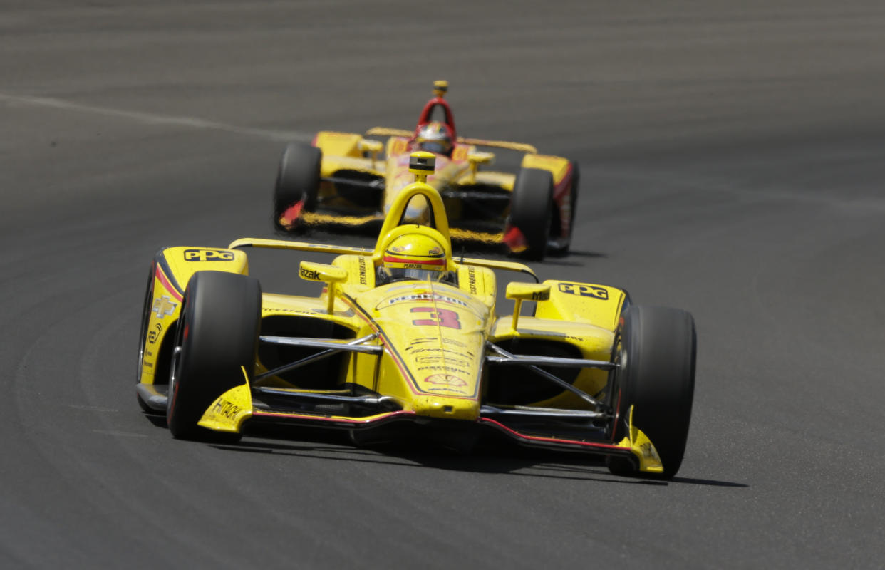 Helio Castroneves, of Brazil, leads Ryan Hunter-Reay through the first turn during the Indianapolis 500 auto race at Indianapolis Motor Speedway, in Indianapolis Sunday, May 27, 2018. (AP Photo/AJ Mast)