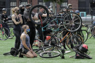 A cyclist kneels during a rally at Cal Anderson Park after the "Ride for Justice," Thursday, June 11, 2020, Seattle. People rode to the park and then took part in a rally to protest against police brutality and racial inequality. (AP Photo/Ted S. Warren)