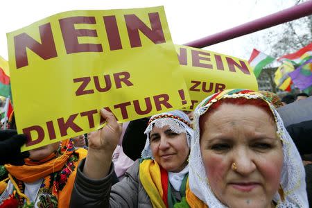 People hold placards with the slogan "No to dictatorship" during a demonstration organised by Kurds, in Frankfurt, Germany, March 18, 2017. REUTERS/Ralph Orlowski