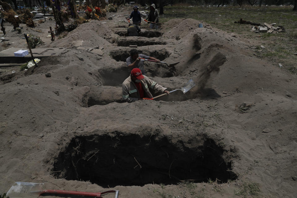 Melvin Sanaurio, front, a gravedigger for 15 years, works at the San Lorenzo Tezonco Iztapalapa cemetery as it makes space for more burials in a section for COVID-19 victims, in the Iztapalapa neighborhood of Mexico City, Tuesday, June 2, 2020. Mexico is passing through the pandemic’s most critical moment with a dramatically increasing number of confirmed and suspected infections. (AP Photo/Marco Ugarte)